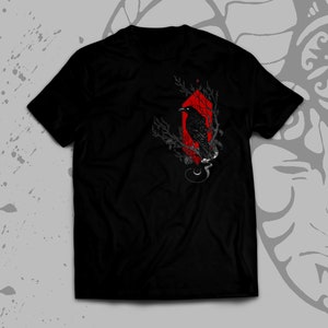 May include: Black t-shirt with a red geometric design featuring a black crow perched on a branch.