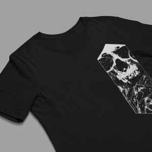May include: Black t-shirt with a white graphic of a skull with intricate details.