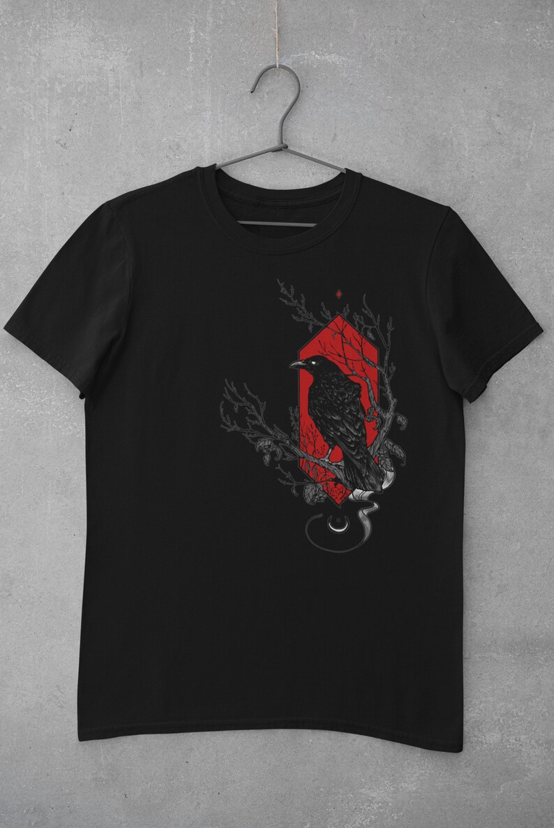 May include: Black t-shirt with a graphic of a crow perched on a branch inside a red geometric shape.