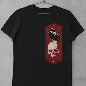 May include: Black t-shirt with a red hexagonal graphic featuring a crow perched on a skull.