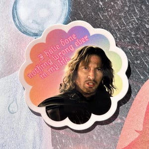 May include: A sticker with a quote from the movie The Lord of the Rings. The sticker has a white cloud-like border with a gradient of colors. The quote reads "I have done nothing wrong ever in my life." The sticker features a portrait of the character Aragorn.