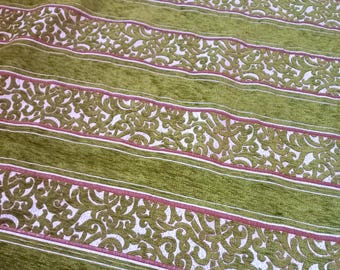 Peut inclure: Gros plan sur un tissu vert avec un motif rayé. Les rayures alternent entre le vert uni et le blanc avec un motif décoratif tourbillonnant. De fines lignes roses bordent les sections blanches.