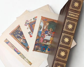 May include: A vintage book with the word "VANGELO" on the spine, featuring a dark brown cover with gold accents. Several colorful illustrations are fanned out next to the book, depicting religious scenes with intricate details and vibrant colors.