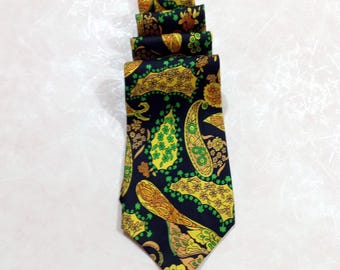 Può includere: Cravatta piegata con motivo paisley nei toni del giallo, verde e arancione su sfondo blu navy. La cravatta è realizzata in tessuto liscio e ha una forma classica.