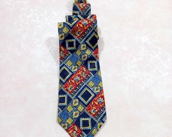 May include: A patterned necktie with a repeating geometric design. The tie features a navy blue background with squares, diamonds, and floral accents in red, yellow, and blue. The tie is a classic accessory.