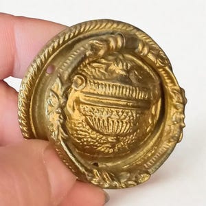 Op de afbeelding: Een witte keramische mok met een zwart handvat en de tekst "But First, Coffee" in een zwarte, vette letter. De mok staat op een wit oppervlak.