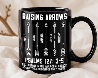 Op de afbeelding: Een zwarte keramische mok met de witte tekst RAISING ARROWS bovenaan en PSALMS 127: 3-5 LIKE ARROW IN THE HAND OF A WARRIOR, SO ARE THE CHILDREN OF ONE'S YOUTH onderaan, met vijf verticale pijlen gelabeld CHOLE, DAVID, AMABEL, SOPHIA, ANTHONY.