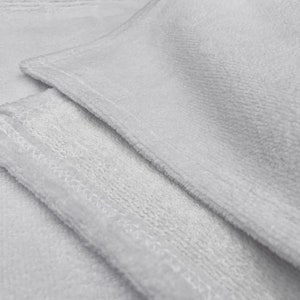 May include: Two white microfiber cloths with a stitched edge. The cloths are folded and layered on top of each other.