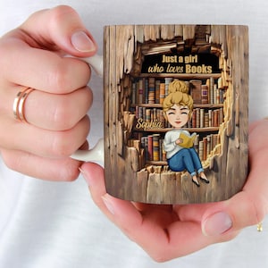 May include: A white ceramic mug with a brown wood-grain design. The mug features a cartoon illustration of a girl sitting in a bookshelf, reading a book. The text "Just a girl who loves Books" is above the girl, and the name "Sophia" is written on the bookshelf.