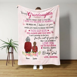 May include: Pink and white fleece blanket with a message to a granddaughter. The message reads "To my Grandaughter Never forget that I love you I hope you believe in yourself as much as I believe in you When life tries to knock you down This old girl will always have your back I can't promise to be here for the rest of your life But I can promise to love you for the rest of mine You will always be my Baby Girl Love, Grandma." The blanket features a cartoon illustration of two women, one with gray hair and the other with brown hair, sitting on a bench with flowers.