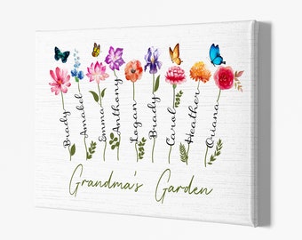 Op de afbeelding: Een witte canvas print met een bloemenontwerp met kleurrijke bloemen en vlinders. De tekst "Grandma's Garden" staat onderaan de print. De namen van acht mensen staan verticaal langs de stelen van de bloemen.
