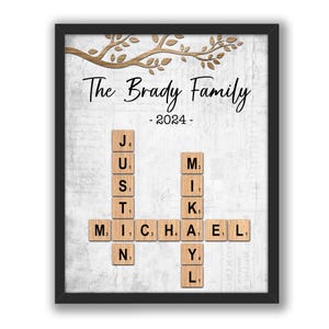 May include: A framed print with a white background and a brown tree branch design. The text "The Brady Family - 2024 -" is at the top of the print. The names "JUSTIN" and "MICHAEL" are spelled out using letter tiles.