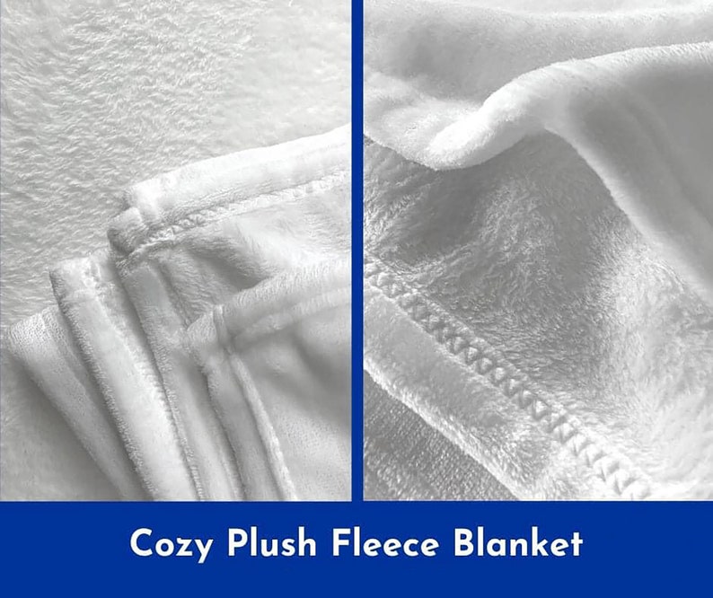 May include: Close-up of a white plush fleece blanket. The blanket is folded and shows the soft texture and stitching.