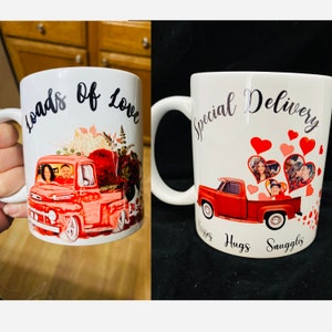 May include: Two white ceramic mugs with a red pickup truck design. One mug says "Loads of Love" and the other says "Special Delivery Kisses Hugs Snuggles".