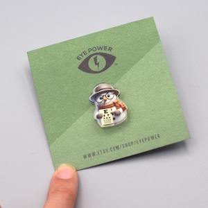 May include: Green card with the text "Eye Power" and a lightning bolt logo. A snowman wearing glasses and holding an eye chart is on the card. The text "www.etsy.com/shop/eyepower" is at the bottom of the card.