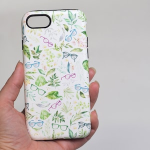 Puede incluir: Funda de teléfono blanca con un patrón de acuarela de hojas verdes y gafas de colores.
