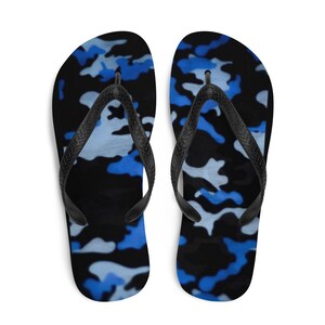 May include: Pair of blue and black camouflage flip flops. The flip flops have a black strap and a blue and black camouflage pattern.