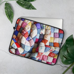Puede incluir: Una funda para portátil con un diseño de patchwork colorido. La funda está hecha de un material suave y duradero, perfecto para proteger tu portátil de arañazos y golpes.