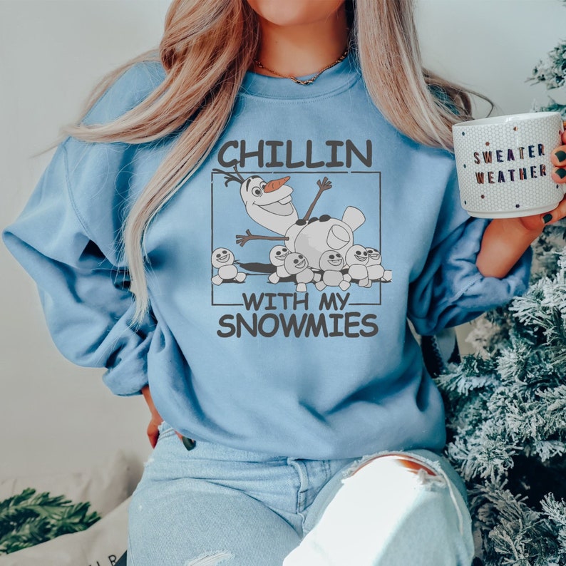 May include: A light blue sweatshirt with a graphic of Olaf from Frozen. The graphic says "Chillin' with my snowmies".