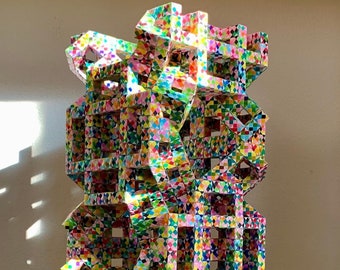 Scultura monumentale a torre origami: arte geometrica colorata in carta