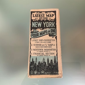 May include: A vintage map and guide of New York City, with the title "Latest Map and Guide of New York." The map includes street, subway, and financial district maps. The cover features a skyline illustration and the text "Four Maps in One."
