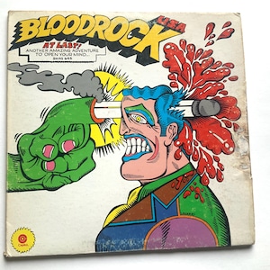 Puede incluir: Portada de álbum vintage de Bloodrock, con una ilustración de estilo cómic. Una mano verde dispara una bala a la cabeza de un hombre, con salpicaduras de sangre roja. El título del álbum está en amarillo y negro, con el texto "Another Amazing Adventure to Open Your Mind..."