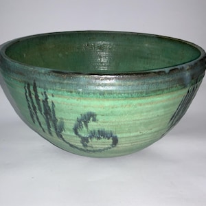 以下が含まれることがあります： 濃い茶色の縁取りと黒い渦巻き模様が施された、大きな緑色の陶器のボウル。ボウルは釉薬仕上げで、手作りのものです。