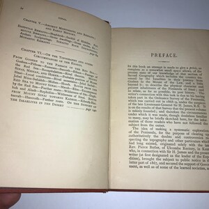 以下が含まれることがあります： 赤い表紙と白いページの開かれた本。本のタイトルは「シナイ」で、ページのテキストは出エジプト記の地形とその他の状況について論じています。この本には序文も含まれています。