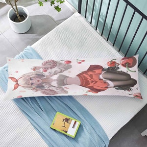 K&ouml;nnte beinhalten: Ein wei&szlig;er Kissenbezug f&uuml;r ein K&ouml;rperkissen mit einer farbenfrohen Anime-Illustration einer Frau mit langen rosa Haaren, die einen roten Rock und ein wei&szlig;es Hemd tr&auml;gt, umgeben von rosa Kirschbl&uuml;ten.