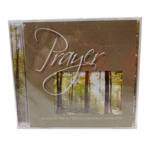May include: A CD case with the word "Prayer" in a cursive font. The cover features a forest scene with sunlight streaming through the trees. The text "SONGS OF THE BLESSINGS AND POWER OF PRAYER" is also visible.