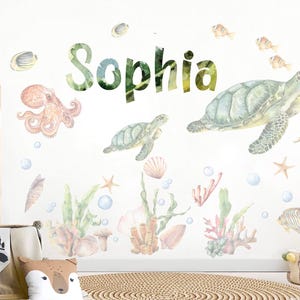 May include: Watercolor wall decals featuring an underwater theme with sea turtles, an octopus, seahorse, and fish. The name "Sophia" is written in green and yellow letters. Includes coral, seashells, and bubbles. Perfect for a child's bedroom.