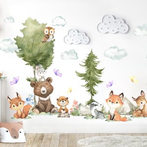 May include: A set of watercolour wall decals featuring a brown bear, a fox, a deer, a wolf, a badger, an owl, a rabbit, and a beaver. The scene includes green trees, mountains, blue clouds, and butterflies arranged on a white wall surface.