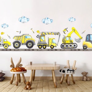 Cute yellow construction truck stickers displayed on a white wall with kids table and animal-themed chairs