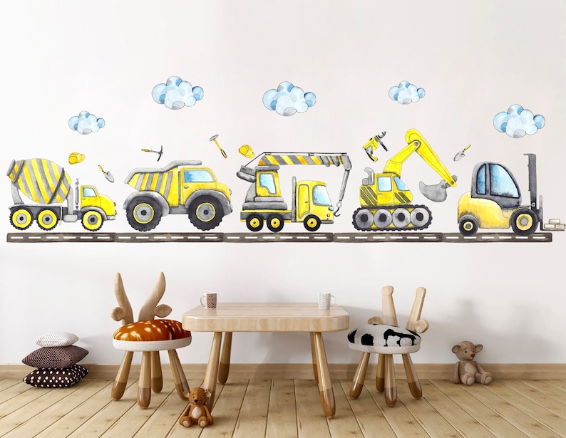 Cute yellow construction truck stickers displayed on a white wall with kids table and animal-themed chairs