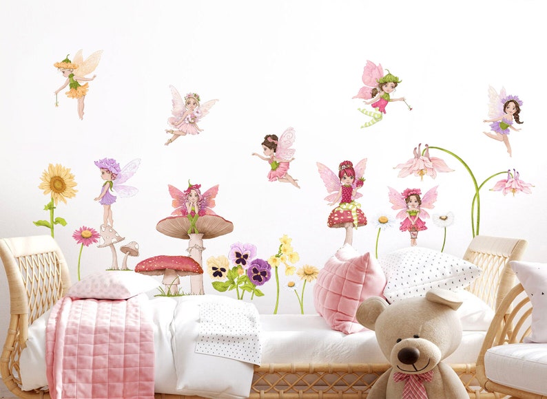 May include: Wall decals featuring whimsical fairies with colorful wings and floral accents. The fairies are depicted in various poses, some standing on mushrooms and flowers. The color palette includes pinks, greens, purples, and yellows, creating a cheerful and enchanting atmosphere.