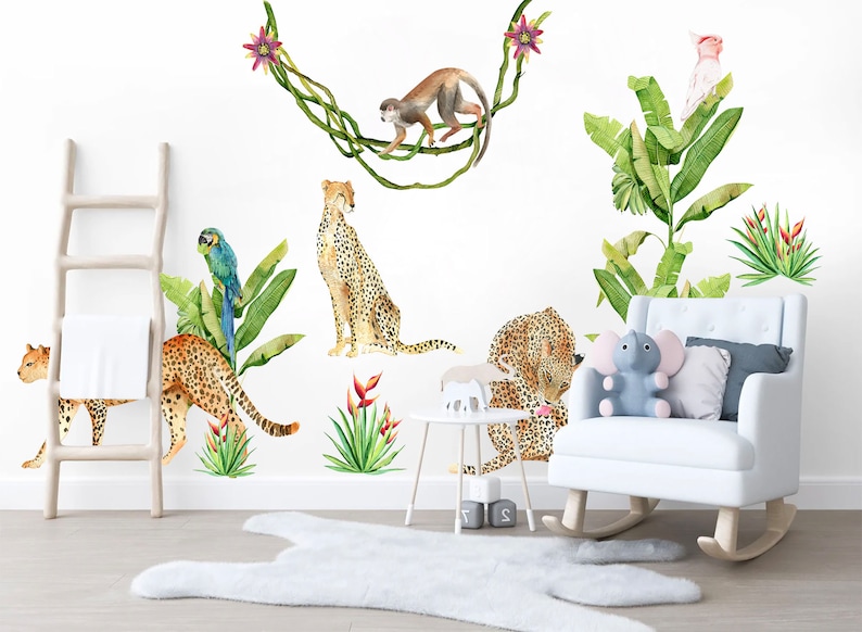 May include: A set of jungle animal wall decals featuring a monkey swinging from vines, a parrot, a pink bird, and four cheetahs. The decals are on a white wall with a white rocking chair, a wooden ladder, and a white rug.