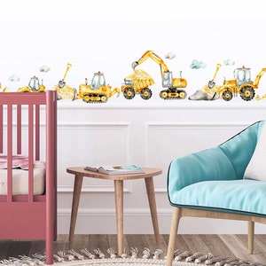 May include: A set of yellow construction vehicle decals featuring a dumper truck, excavator, bulldozer, and a crane. The decals are arranged in a line on a white wall, with clouds and other details in the background.