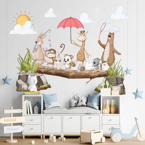 May include: A white wooden bench with a light blue cushion and a white wooden shelf underneath. The shelf is filled with books and a small wooden house. The wall behind the bench is decorated with a whimsical woodland scene featuring a red umbrella, a giraffe, a kangaroo, a monkey, a fox, a hedgehog, and a bear. The wall also has a sign with the words "Neverland", "Narnia", and "Forest".