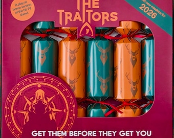 May include: A boxed set of The Traitors Christmas crackers in teal and orange with a deer head pattern. The packaging features the text The Traitors, A play at home version of the hit TV show, 2026, and Get them before they get you.