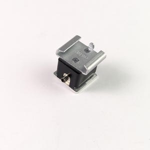 May include: A small, silver-colored camera accessory with a black base. The top features a metal bracket with two parallel arms. The item is on a white background. The word "JAPAN" is visible on the top.