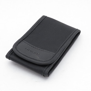 Könnte beinhalten: Ein schwarzes rechteckiges Etui mit gebogenem oberem Klappdeckel. Das Etui besteht aus einem strukturierten Stoff und hat einen lederartigen Akzent mit geprägtem Text. Das Etui ist geschlossen und liegt auf einer weißen Oberfläche.