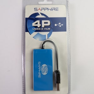 Peut inclure: Un hub USB 2.0 Sapphire 4P bleu dans un emballage plastique transparent. Le hub est de forme rectangulaire avec le logo Sapphire et un câble noir avec un connecteur USB. L'emballage porte le logo Sapphire et des informations sur le produit.