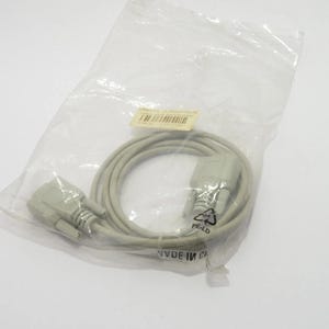 May include: A gray computer cable with connectors at each end, coiled inside a clear plastic bag. The connectors are light gray and have multiple pins. A small label is visible on the bag.