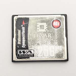 May include: A Lexar Professional CompactFlash memory card with a silver face and black border. The card has a 40X speed rating and a 256MB capacity. The card also features Write Acceleration Technology.