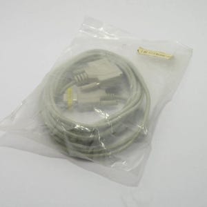 May include: A coiled, light gray computer cable with connectors at each end, packaged in a clear plastic bag. The cable appears to be new and unused. A small, yellowed sticker is attached to the bag.