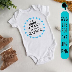 May include: White baby onesie with a blue heart border and the text "Cute Smart & A little bit Dramatic" in black.