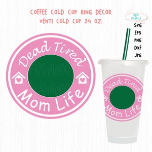 May include: A pink and white cold cup ring decor with the text "Dead Tired Mom Life" and a green center. The image also shows a clear plastic Venti cold cup with a green straw and the same design.