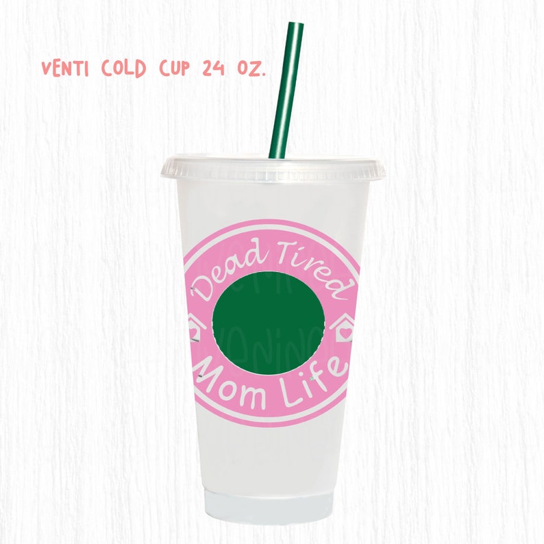 May include: A clear plastic Venti cold cup with a pink and green design. The cup has a green straw and a pink circle with the words "Dead Tired Mom Life" in white. The cup is 24 oz.
