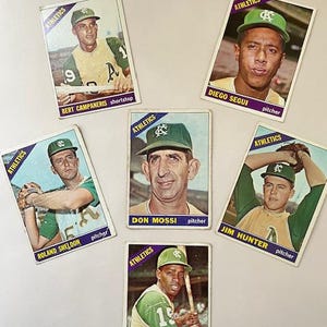 May include: A collection of 6 baseball cards featuring players from the Athletics team. The cards are in good condition and feature photos of the players in their uniforms. The cards include the names of the players and their positions.