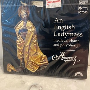 May include: A black and white album cover with a gold-colored image of a woman in a robe. The album title is "An English Ladymass" with the text "medieval chant and polyphony" below. The album is by "Anonymous 4".